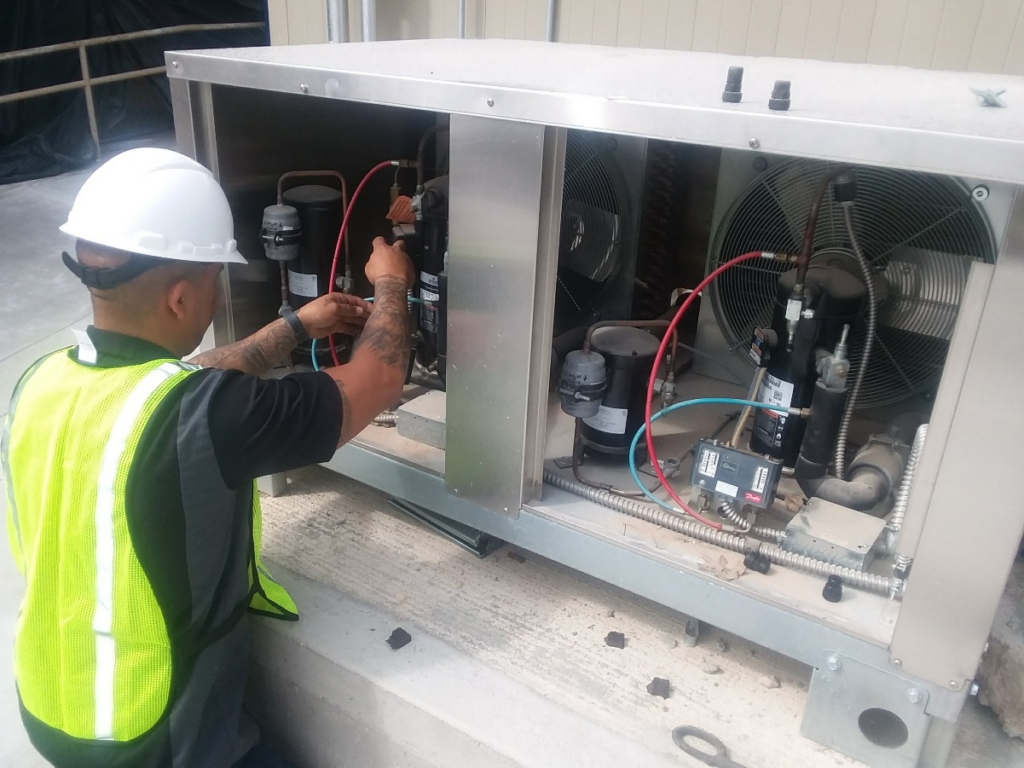 Technician performing preventive commercial refrigeration service in San Antonio to maintain safe temperatures and support food safety compliance